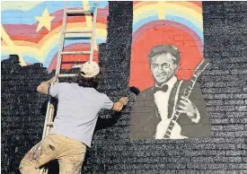  ?? [PHOTO BY DAVID CARSON, ST. LOUIS POST-DISPATCH VIA AP] ?? Joe Albanese replaces an old mural at Delmar Loop in St. Louis with a new painting Saturday that will feature the album cover of a new Chuck Berry album. They were surprised to hear that the music legend died as they were working on the project....