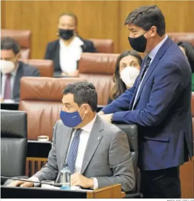  ?? MARÍA JOSÉ LÓPEZ / EP ?? Juan Marín pasa a su sitio en el Parlamento, junto a Juanma Moreno.