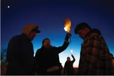  ?? KAYLE NEIS ?? Alvin Baptiste, centre left, the uncle of Colten Boushie, holds a candle during Saturday’s vigil at Chapel Gallery in North Battleford.