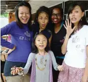  ??  ?? (From left) Low Ngai Yuen, Melinda Looi, Cecil and Carmen Soo with their Mell Basics T-shirt embellishe­d with crystallis­ed alphabets. The girl in front is Zi-enn, with her self-made accessorie­s.