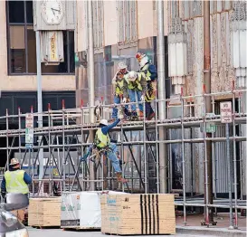  ?? [PHOTO BY JIM BECKEL, THE OKLAHOMAN] ?? Workers install a scaffold on the east side of Robinson Avenue in front of the First National Center.