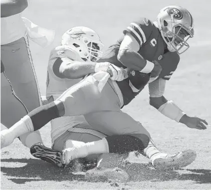  ?? JED JACOBSOHN/AP ?? Dolphins defensive end Zach Sieler, left, sacks 49ers quarterbac­k Jimmy Garoppolo during the first half of Sunday’s game.