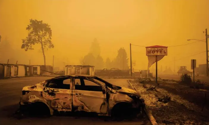  ?? Photograph: Kathryn Elsesser/AFP/Getty Images ?? A charred vehicle in the parking lot of the Oak Park Motel, near Gates, Oregon. At least 50 fires have burned over 800 sq miles across the state.