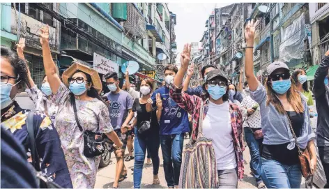  ??  ?? Demonstran­ten machen den Drei-Finger-Gruß während sie gegen den Militärput­sch auf die Straße gehen.