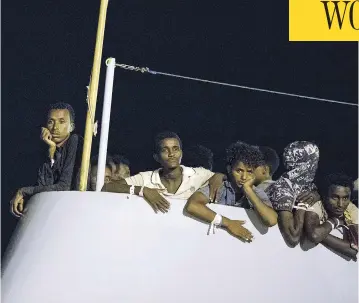  ?? FRANCESCO RUTA/ANSA VIA THE ASSOCIATED PRESS ?? Migrants wait to disembark from the Protector at Pozzallo, Sicily, early Monday after a half-dozen European countries promised to take some of them in rather than have Italy process their asylum claims alone.