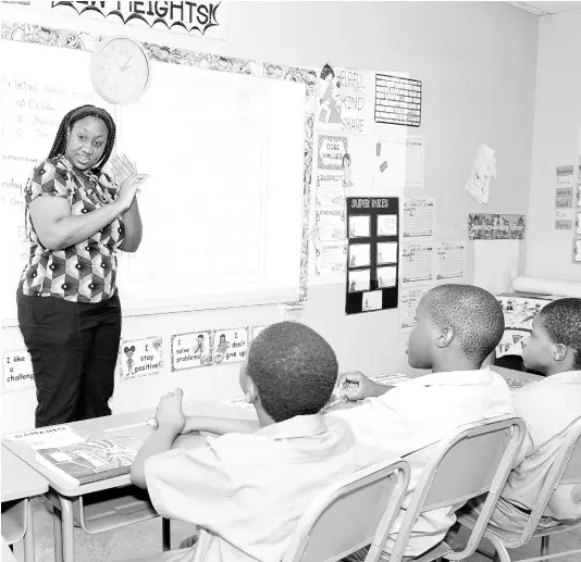  ?? CONTRIBUTE­D PHOTOS ?? Sashaoir Hewitt (centre), grade five teacher at the Danny Williams School for the Deaf, signs during a class session with her grade five students.