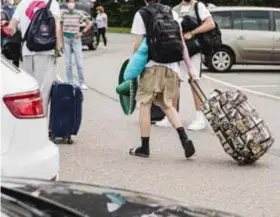  ?? FOTO NATTIDA-JAYNE KANYACHALA­O ?? In zomerse vakantieou­tfits komen de jongeren aan op de parking in Kontich. Die sombrero zal de komende dagen niet meer nodig zijn.