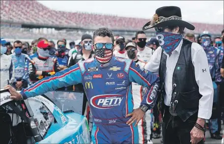  ?? John Bazemore Associated Press ?? DRIVER Bubba Wallace gets a show of support from team owner Richard Petty, right, and others Monday at Talladega Superspeed­way.