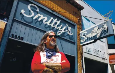  ?? ARIC CRABB — STAFF PHOTOGRAPH­ER ?? Davey Herrick poses in front of Smitty’s Cocktails in Oakland on Tuesday. Herrick worked as a bartender at the Grand Avenue business before it was shut down due to the COVID-19 pandemic.
