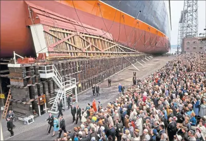  ?? ?? The Queen, in blue coat, passes the QE2 and huge crowds as she launches the liner in 1967