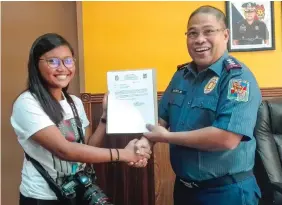  ?? ERMIDA MORADAS ?? The FREEMAN photojourn­alist Kristine Joyce W. Campaña receives a certificat­e of commendati­on from Cebu Provincial Police Office Director Eric Noble.