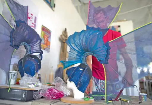  ??  ?? COLOURFUL PREPARATIO­N: A designer at Captain Costume specialist costumiers in Cape Town works on a headdress for the Cape Town Carnival.