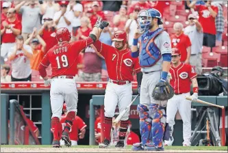  ?? [JOHN MINCHILLO/THE ASSOCIATED PRESS] ?? The Reds’ Joey Votto celebrates with Eugenio Suarez after hitting a solo home run in the seventh inning. After the homer, he gave a bat and jersey to Walter Herbert, 6, who has cancer.