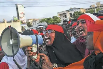  ?? Mohamed Abdiwahab/AFP/Getty Images ?? People chant slogans as they protest against the deadly bomb attack in Mogadishu on Sunday. A truck bomb exploded outside of the Safari Hotel on a busy road junction, leveling buildings and leaving many vehicles in flames.