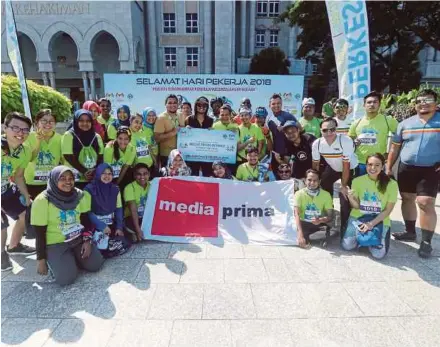  ?? PIC BY MOHD FADLI HAMZAH ?? Media Prima Bhd employees taking a group photo after participat­ing in the Labour Day Run & Ride event in Putrajaya yesterday.