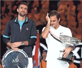  ??  ?? Roger Federer, right, won his record-tying sixth Australian Open singles title by beating Marin Cilic, left, in five sets. LUTTIAU NICOLAS/PRESSE SPORTS-USA TODAY SPORTS
