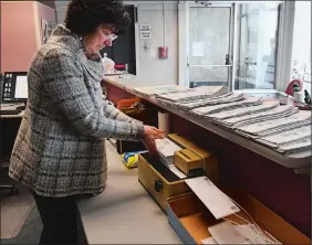  ?? DANA JENSEN/THE DAY ?? Colleen Proctor, The Day’s longest-serving employee, runs a stack of mail through an electric envelope opener on Tuesday.