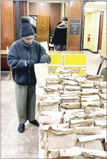  ?? Katie West • Times-Herald ?? Carolyn Holt volunteers at the Graham Memorial Soup Kitchen this morning, packing sacked lunches for take-out. The Soup Kitchen is opened each Monday, from 11 a.m. until 1 p.m., for those who need a meal.