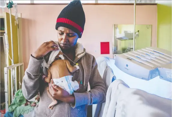  ?? PHOTOS: KHADIJA FARaH/FOR THE WASHINGTON POST ?? Catherine Wangari, 18, holds her baby, Sheilla, at Kenyatta National Hospital in Nairobi. The baby was born with jaundice.