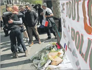  ?? AP PHOTO ?? People hug Friday at the place where a police officer was killed Thursday on the Champs Elysees in Paris.