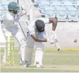  ?? (Photos: Joseph Wellington) ?? Odean Smith of Trinidad and Tobago Red Force being bowled by Jamaica Scorpions’s Nikita Miller (out of photo), as wicketkeep­er Aldaine Thomas reacts during their West Indies four-day cricket match at Sabina Park yesterday.