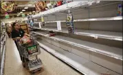  ?? JOE RAEDLE / GETTY IMAGES ?? A shopper in Miami is greeted by bare shelves after the supply of bottled water was emptied at a grocery store Wednesday as residents prepared for a possible direct hit from Hurricane Irma.