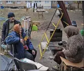  ?? ?? DEVASTATIO­N: Women cooking on a
makeshift stove in Bucha, Ukraine