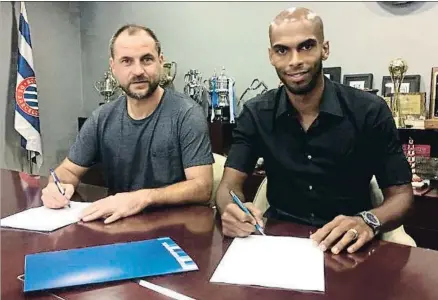  ?? RCD ESPANYOL ?? El central Naldo firmando junto al responsabl­e del área deportiva españolist­a, Òscar Perarnau