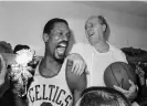  ?? Anonymous/AP ?? Bill Russell, left, holds a corsage sent to the dressing room as he celebrates with Celtics coach Red Auerbach after defeating the Los Angeles Lakers to win their eighth straight NBA Championsh­ip in 1966. Photograph: