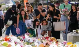  ?? Photograph: Mark Baker/AP ?? Members of the public add flowers to the expanding mass near the crime scene at Bondi Junction in Sydney, where six people were stabbed to death at Westfield Shopping Centre.