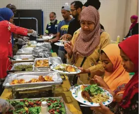  ?? Godofredo A Vásquez / Staff photograph­er ?? Fathima Nushrath and her two daughters Zaynab and Zhara are served Iftar at the Houston Masjid of Al-Islam during a Ramadan gathering last year.
