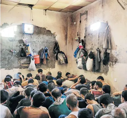  ??  ?? Dieses Bild vom Dezember 2017 zeigt mutmaßlich­e IS-Kämpfer in einem provisoris­chen Gefängnis in Mossul. Auch heimische Jihadisten befinden sich im Irak und in Syrien in Haft.