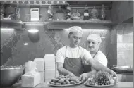  ?? TAMARA ABDUL HADI/WASHINGTON POST SERVICE ?? Firas, left, and Abu Ali, main chef at Barbar restaurant in Beirut, with a plate of falafel and one of vegetables.