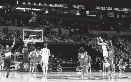  ?? Tim Nwachukwu / Getty Images ?? Jalen Suggs, second from right, kept Gonzaga’s perfect season alive with a buzzer-beating 3-pointer in overtime against UCLA in the Final Four in Indianapol­is.