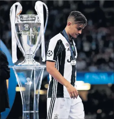  ??  ?? POLÉMICA. Dybala pasa por el trofeo de la Champions tras recibir la medalla de plata en Cardiff.