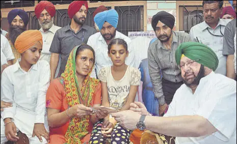 ?? SAMEER SEHGAL/HT ?? Chief minister Capt Amarinder Singh with the family of martyr Paramjit Singh at Vein Poin village in Tarn Taran on Sunday.