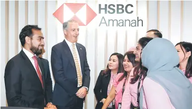  ?? — Gambar Bernama ?? MESRA: Milne (dua, kiri) dan Ketua Pegawai Eksekutif HSBC Amanah Malaysia Berhad, Oz Ahmed (kiri) mengabadik­an kenangan sejenak bersama kakitangan mereka selepas pelancaran cawangan HSBC Amanah Malaysia Sri Petaling semalam.