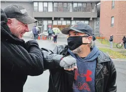  ?? CLIFFORD SKARSTEDT EXAMINER ?? Dan Hennessey, left, an advocate for homelessne­ss, greets Brad Williams at the One Roof Community Centre across from the Brock Mission in Peterborou­gh. Williams used to use the homeless shelters in the city.