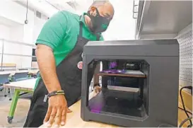  ?? KENNETH K. LAM/BALTIMORE SUN ?? Charter school Green Street Academy’s director of innovation, Harry Preston, checks on a 3D printer at the school’s advanced manufactur­ing lab inside the Elijah E. Cummings Innovation Center.