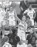  ?? ADAM CAIRNS/COLUMBUS DISPATCH VIA IMAGN CONTENT SERVICES, LLC ?? Ohio State guard Madison Greene, top, takes a shot over Maryland guard Ashley Owusu, middle left, and guard Faith Masonius, right, during the third quarter Monday in Columbus.