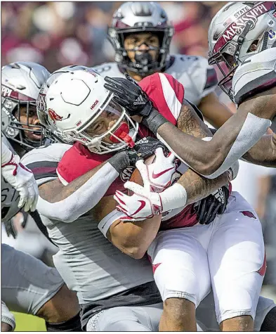  ?? NWA Democrat-Gazette/BEN GOFF ?? Arkansas running back Devwah Whaley is wrangled by Mississipp­i State’s Jamal Peters (right) and Leo Lewis during Saturday’s game at Davis Wade Stadium in Starkville, Miss. The Razorbacks fell to 2-9 for the season, matching the most losses in school history.