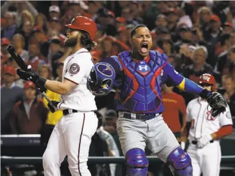  ?? Pablo Martinez Monsivais / Associated Press ?? Chicago catcher Willson Contreras reacts after Wade Davis struck out Washington’s Bryce Harper (left) to end a game that took more than 4½ hours and was filled with odd plays.