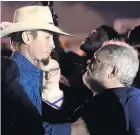  ??  ?? Stephen Willeford, right, hugs Johnnie Langendorf­f during a vigil for the victims.