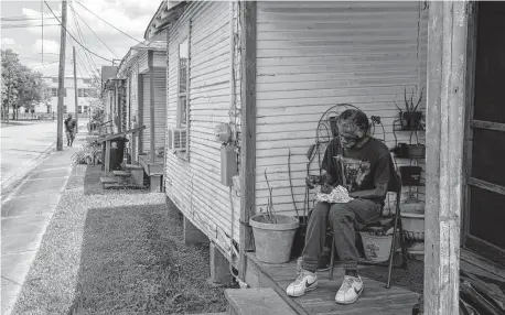  ?? Godofredo A. Vásquez / Staff photograph­er ?? Donald Edwards, 69, eats lunch on his front porch in Fifth Ward. Fifth Ward Community Redevelopm­ent Corporatio­n bought this cluster of homes to preserve them as affordable units.