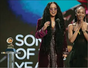  ?? ROBERT GAUTHIER/LOS ANGELES TIMES/TNS ?? H.E.R., left, and Tiara Thomas accept the award for Song Of The Year at the 63rd Grammy Award outside Staples Center on March 14 in Los Angeles.