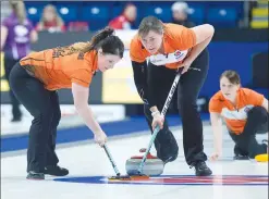  ?? Canadian Press photo ?? Wild Card team second Jessie Haughian, right, delivers a rock as third Cary-Anne McTaggart, left, and lead Kristie Moore sweep as they play Prince Edward Island at the Scotties Tournament of Hearts at Centre 200 in Sydney, N.S. on Sunday.