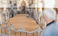  ?? FOTOS: JANA MACK ?? Zwiefalten­s Pfarrer Paul Zeller blickt auf die Holzeinhau­sung der Baufläche im Münster hinab. Bis 2019 muss er für Gottesdien­ste ausweichen.