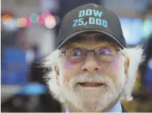  ?? AP PHOTO ?? HATS ON: Stock trader Peter Tuchman, above, is among many sporting a Dow 25,000 hat yesterday at the New York Stock Exchange.