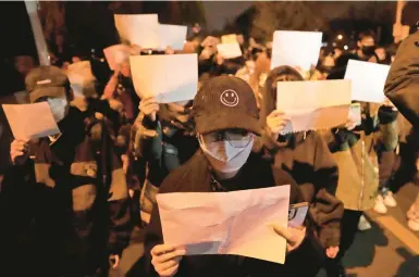  ?? NG HAN GUAN/AP ?? Protesters hold blank papers, symbolizin­g words internet users aren’t allowed to post, amid protests Sunday in Beijing.