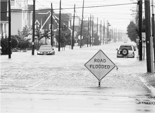  ?? Lori M. Nichols / Glo ucester County Times via The Associat
ed Press ?? A car is stuck in floodwater­s Friday in Sea Isle City, N.J., after the state was pounded by rain and strong winds linked to Hurricane Joaquin, which wreaked havoc across the Bahamas. The threat to the U.S. East Coast has since been downgraded.